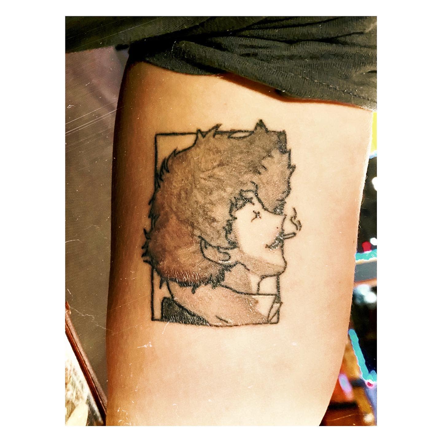 Tattoo of Spike Spiegel from Cowboy Bebop, smiling and smoking, framed within a rectangular outline
